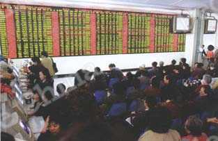 
済南市の株式ホールで、変動する株価のボードに見込む市民たち
